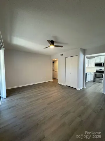 a view of empty room with wooden floor