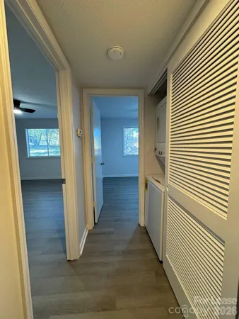 a view of a hallway with wooden floor and staircase