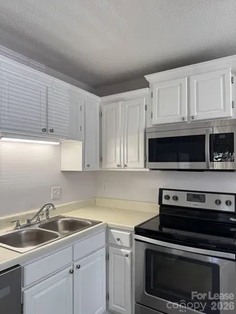 a kitchen with white cabinets and stainless steel appliances