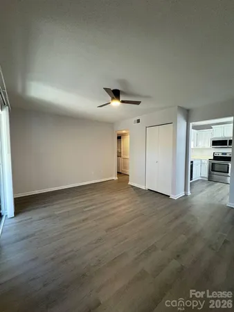 a view of empty room with wooden floor and window