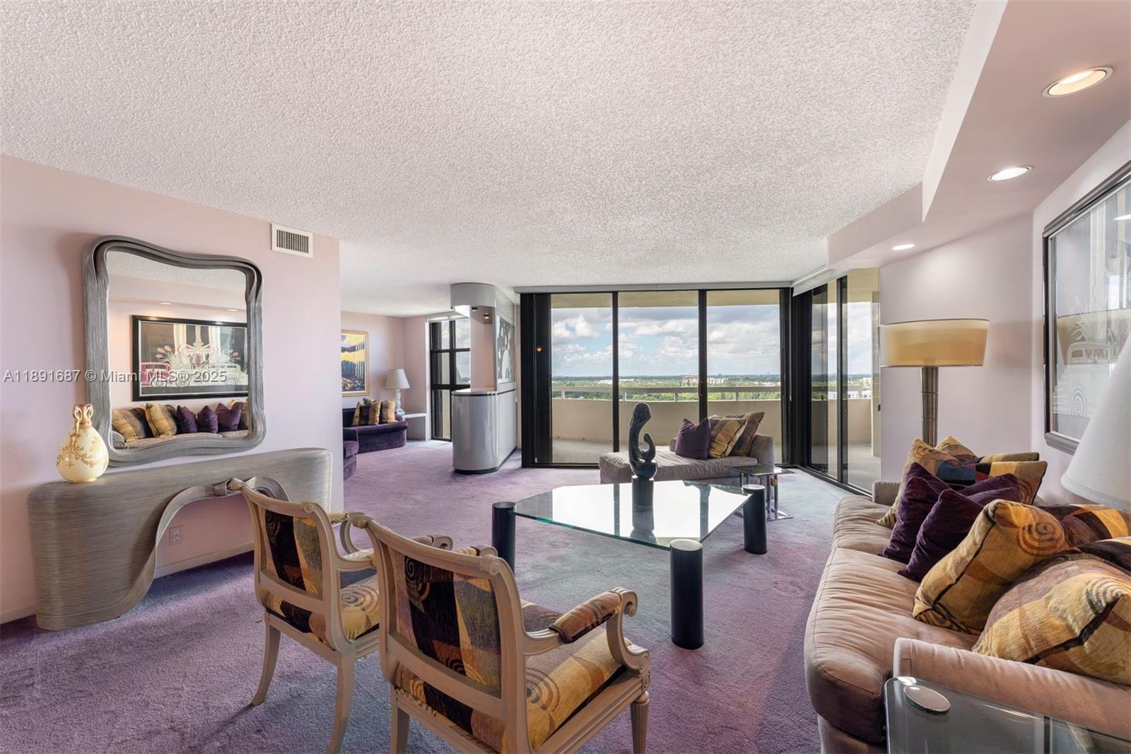 a view of a livingroom with furniture and floor to ceiling window