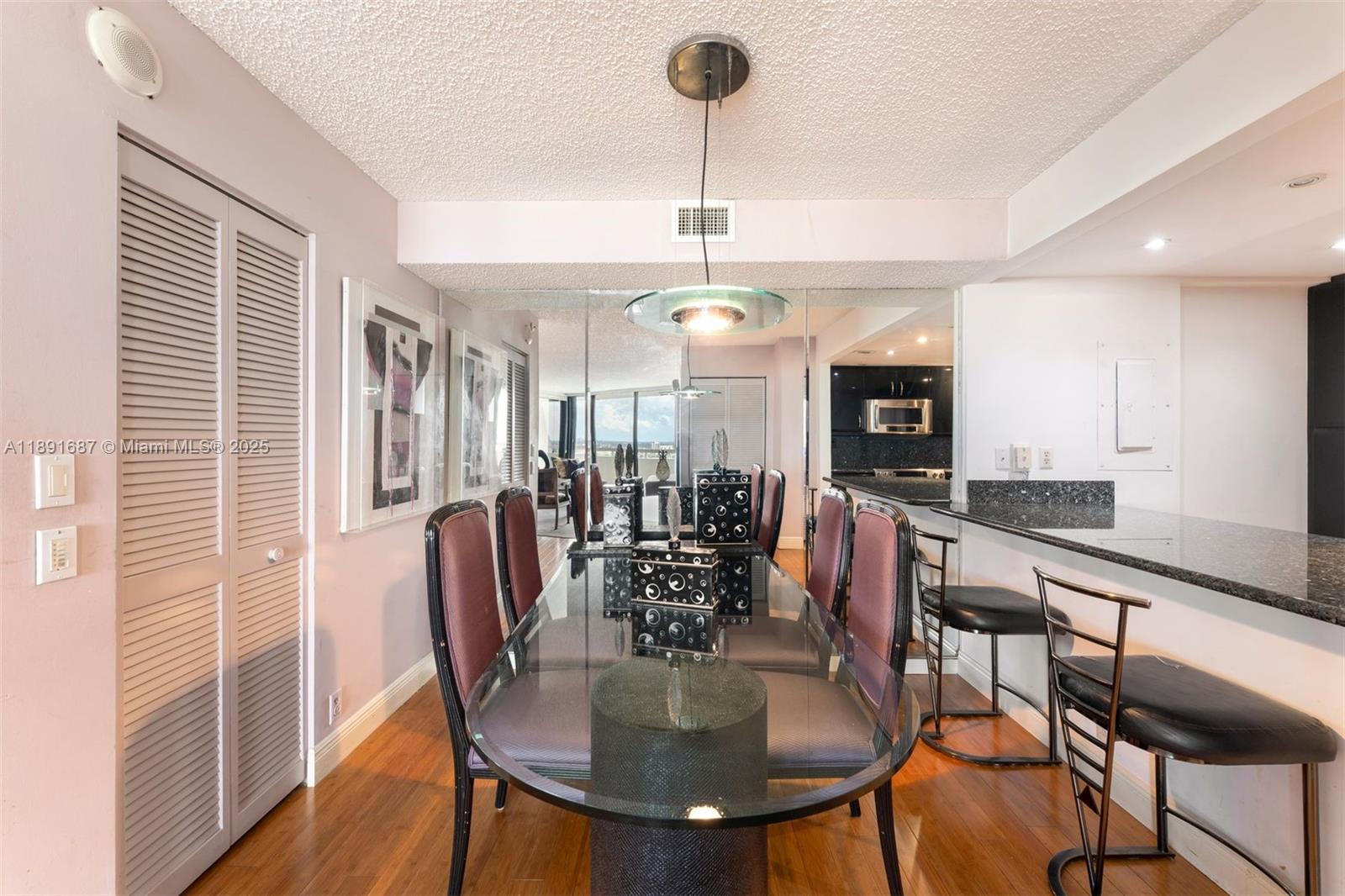 1000 Quayside Terrace, Unit PH9 Miami, FL 33138 - Photo 13 of 27 a kitchen with stainless steel appliances granite countertop a dining table chairs and white cabinets