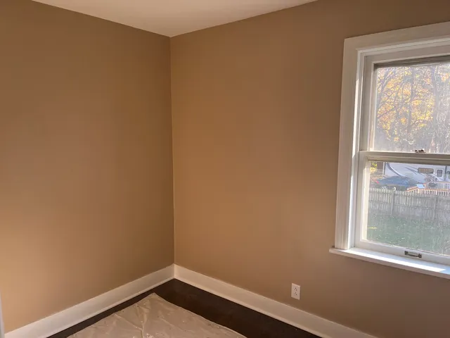 a view of a small space with wooden floor and a window