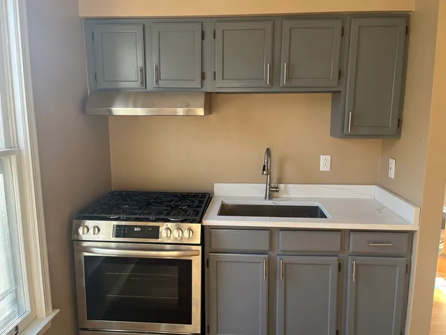 a kitchen with stainless steel appliances granite countertop a sink stove and cabinets