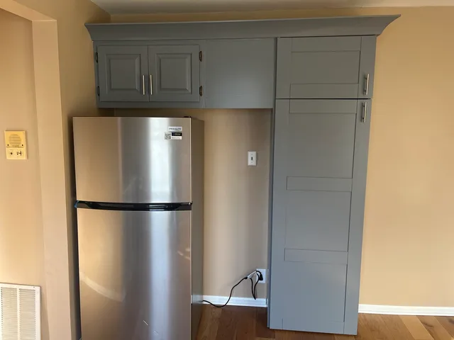 a white refrigerator freezer and a wooden cabinets