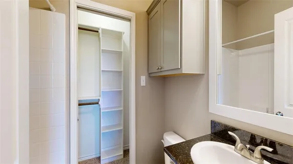 a bathroom with a sink vanity and toilet