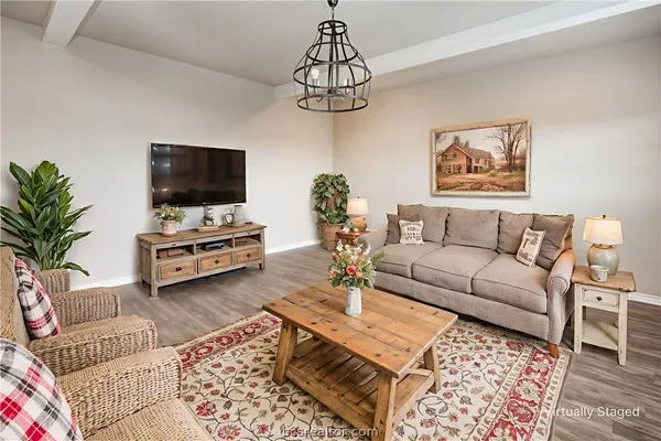 a living room with furniture kitchen view and a large window