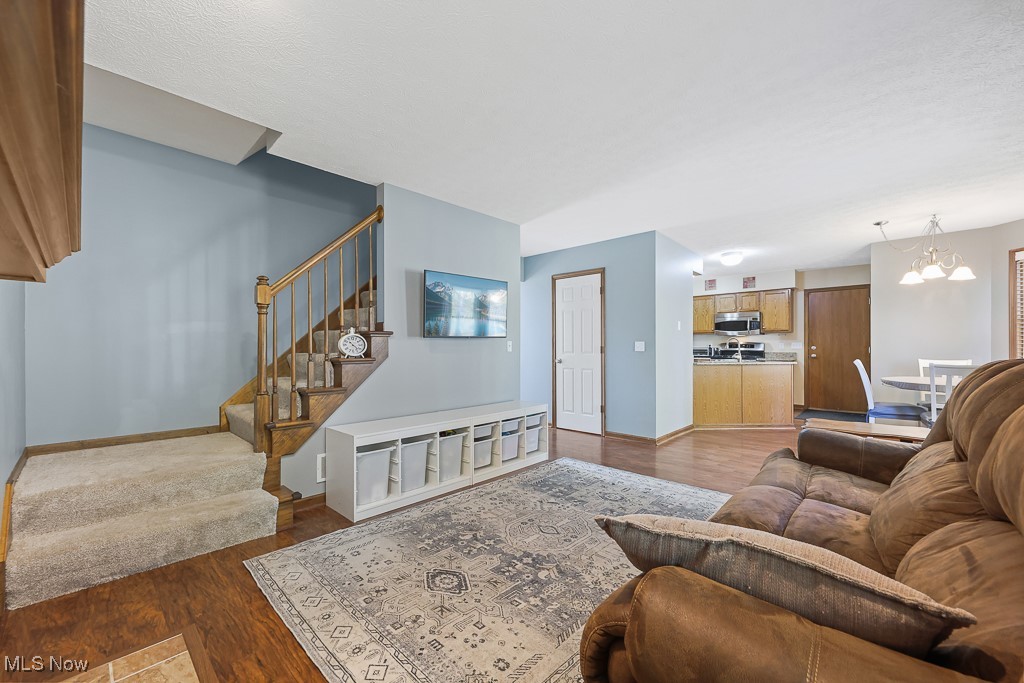 3982 Baird Road Stow, OH 44224 - Photo 8 of 50 Living area featuring wood finished floors, stairway, and a chandelier
