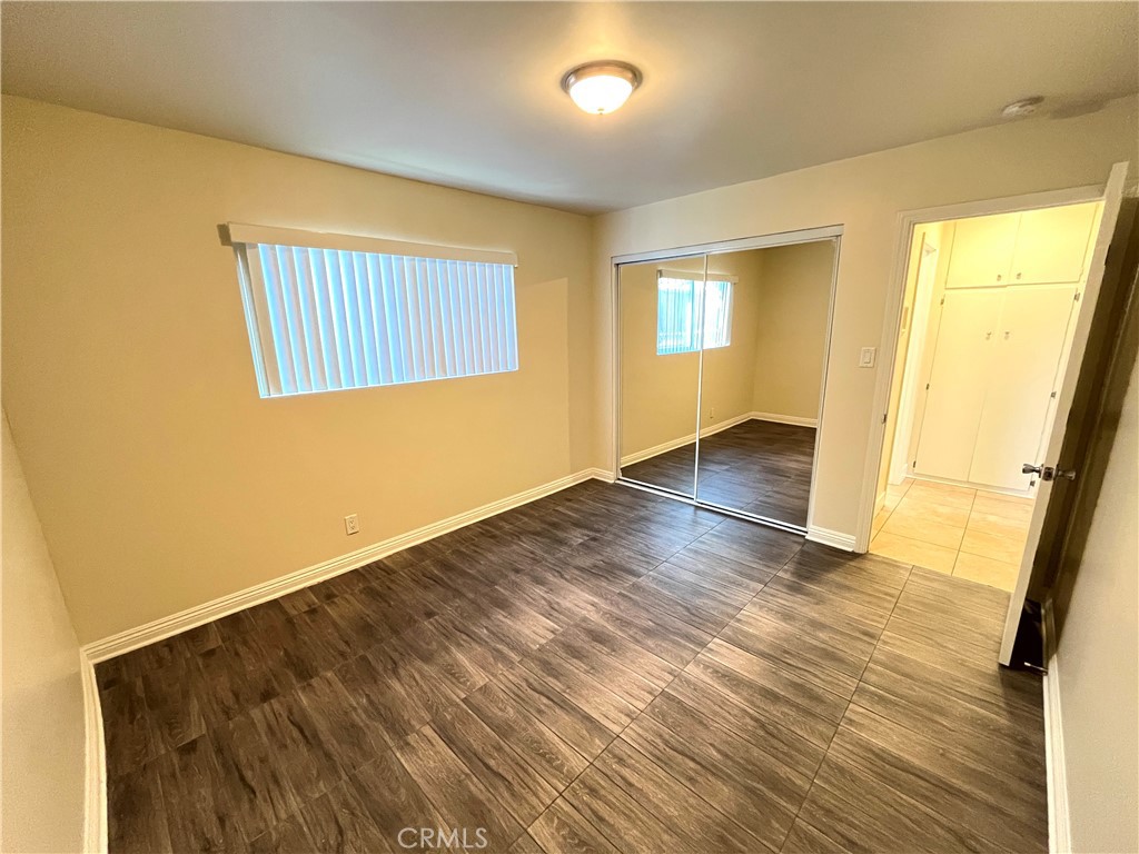 4329 East 55th Street, Unit E Maywood, CA 90270 - Photo 11 of 12 an empty room with wooden floor and windows