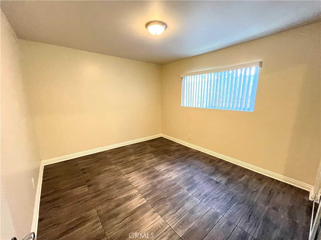 4329 East 55th Street, Unit E Maywood, CA 90270 - Photo 10 of 12 an empty room with wooden floor and windows