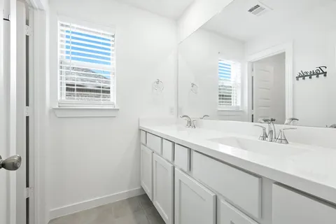 a bathroom with a double vanity sink and a mirror