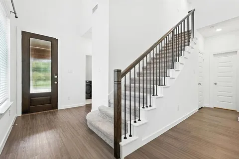 a view of a hallway with wooden floor and entryway