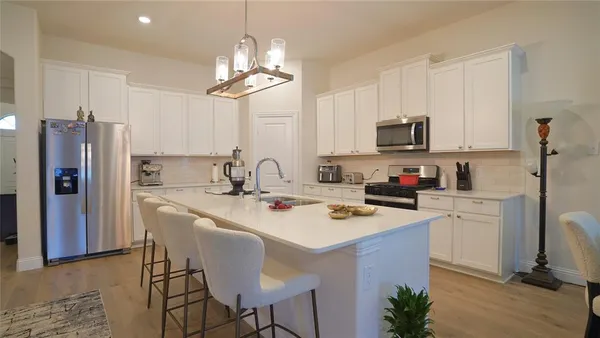 a kitchen with refrigerator a sink and chairs