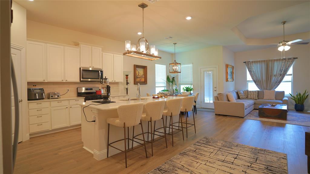 1101 Ginger Road Aubrey, TX 76227 - Photo 16 of 16 a kitchen with stainless steel appliances a dining table chairs stove a refrigerator and cabinets