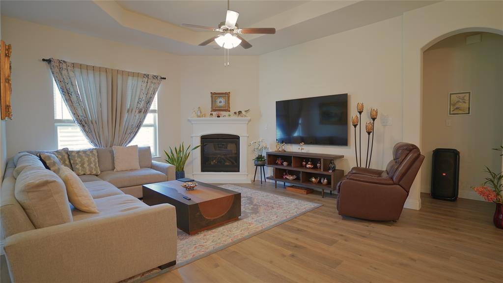1101 Ginger Road Aubrey, TX 76227 - Photo 3 of 16 a living room with furniture a flat screen tv and a fireplace