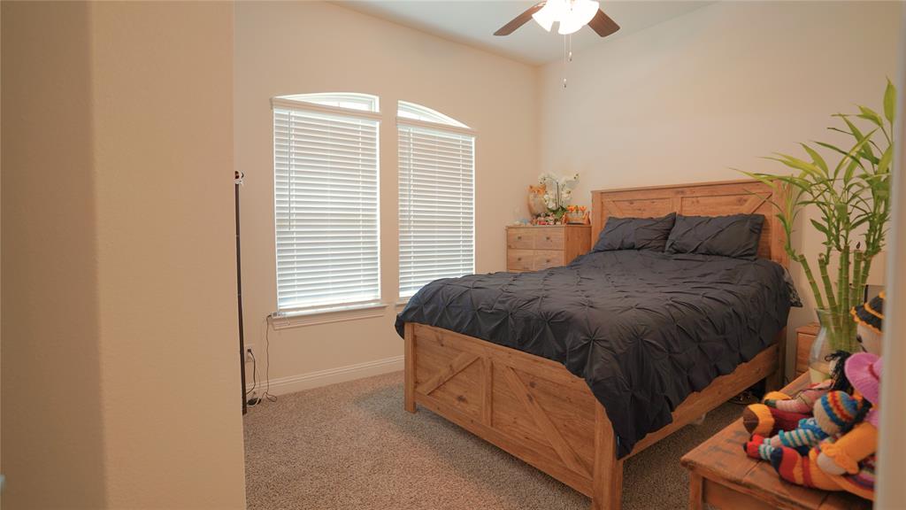 1101 Ginger Road Aubrey, TX 76227 - Photo 7 of 16 a spacious bedroom with a bed and a chandelier