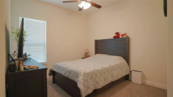 a bathroom with a granite countertop sink a toilet and shower curtain