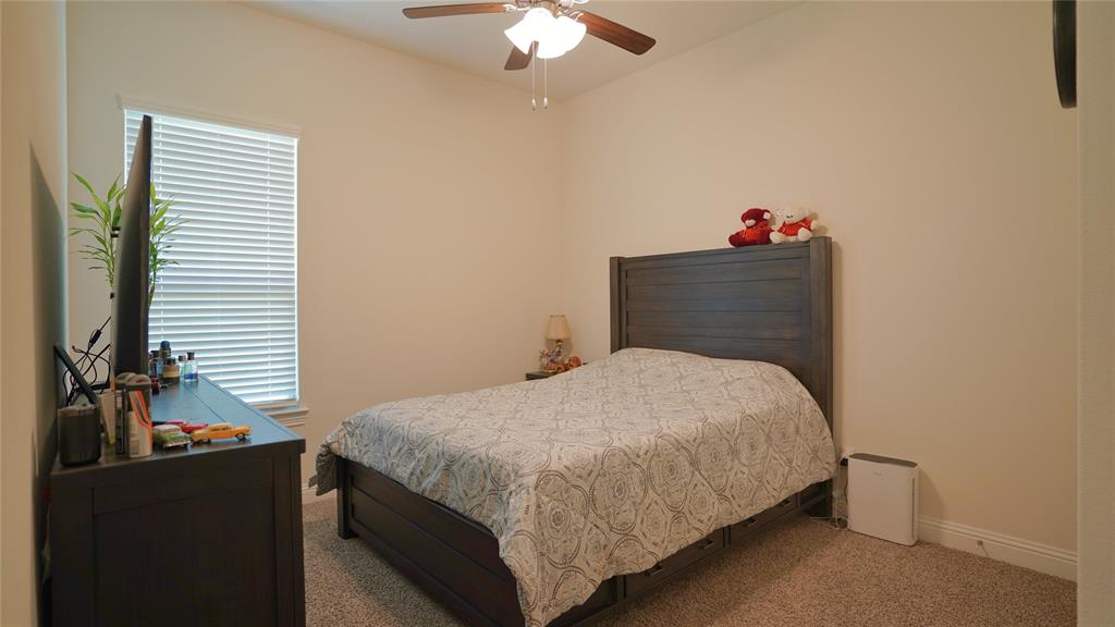 1101 Ginger Road Aubrey, TX 76227 - Photo 9 of 16 a bedroom with a bed and a chandelier