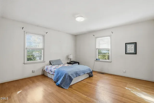 a spacious bedroom with a bed and a window