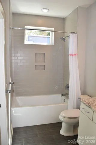 a bathroom with a toilet and a bath tub