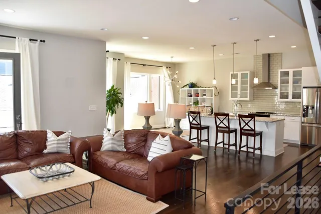 a living room with furniture wooden floor and a view of kitchen
