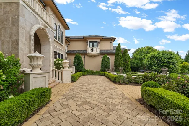a front view of a house with a yard and potted plants