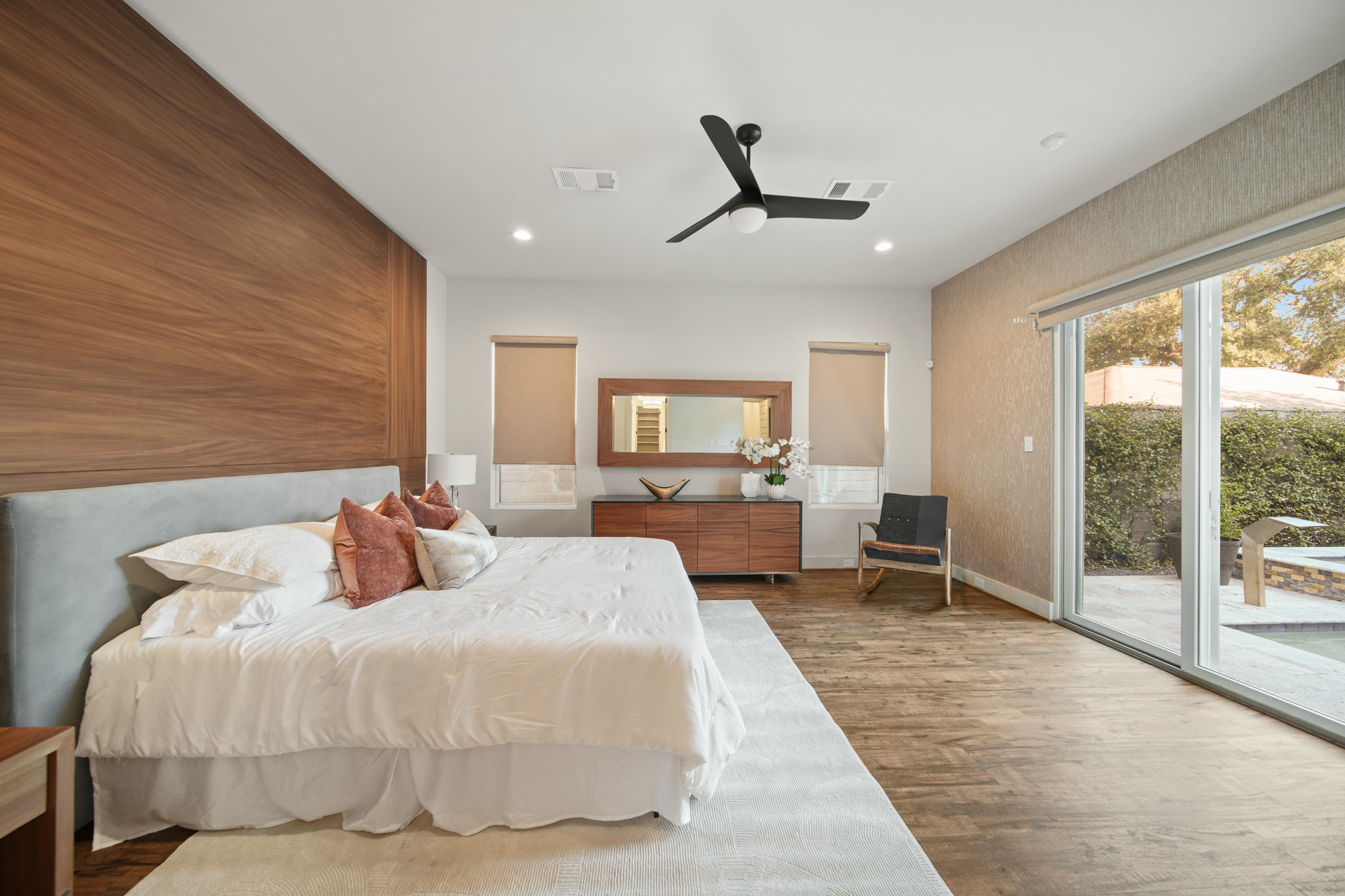 5434 Windswept Lane Houston, TX 77056 - Photo 20 of 45 Where natural light meets refined design: a primary bedroom featuring a bold statement wall and effortless access to the pool and spa.