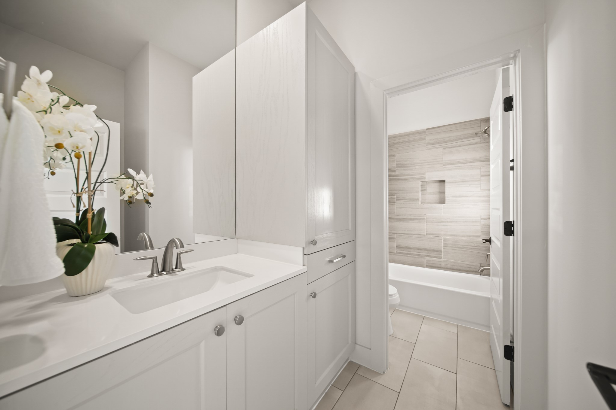 5434 Windswept Lane Houston, TX 77056 - Photo 33 of 45 Charming secondary bathroom with plenty of storage space, quartz countertops, a large mirror, and a shower/tub combo.