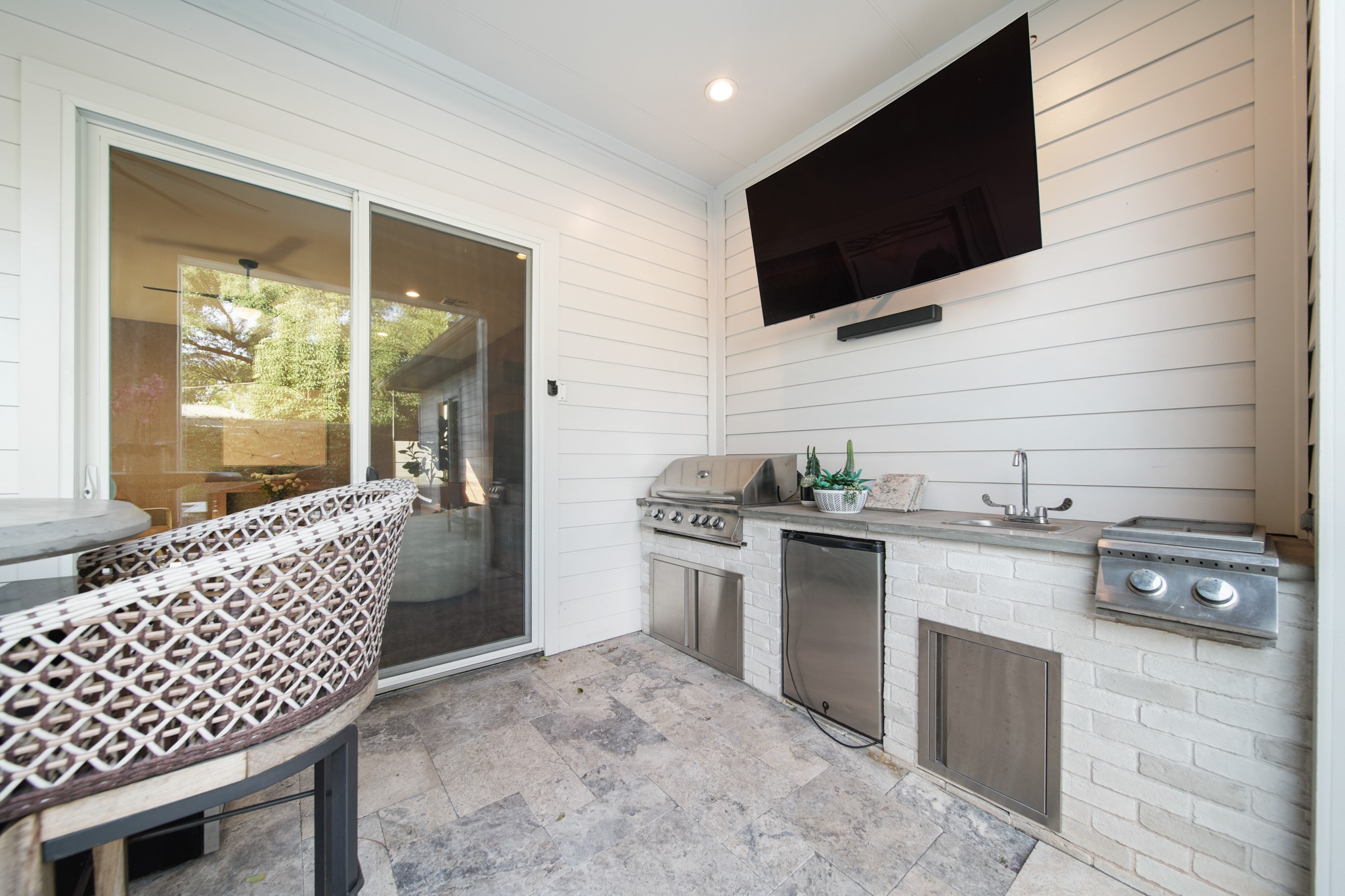 5434 Windswept Lane Houston, TX 77056 - Photo 43 of 45 Where culinary excellence meets outdoor elegance: a covered summer kitchen equipped with premium stainless steel appliances.