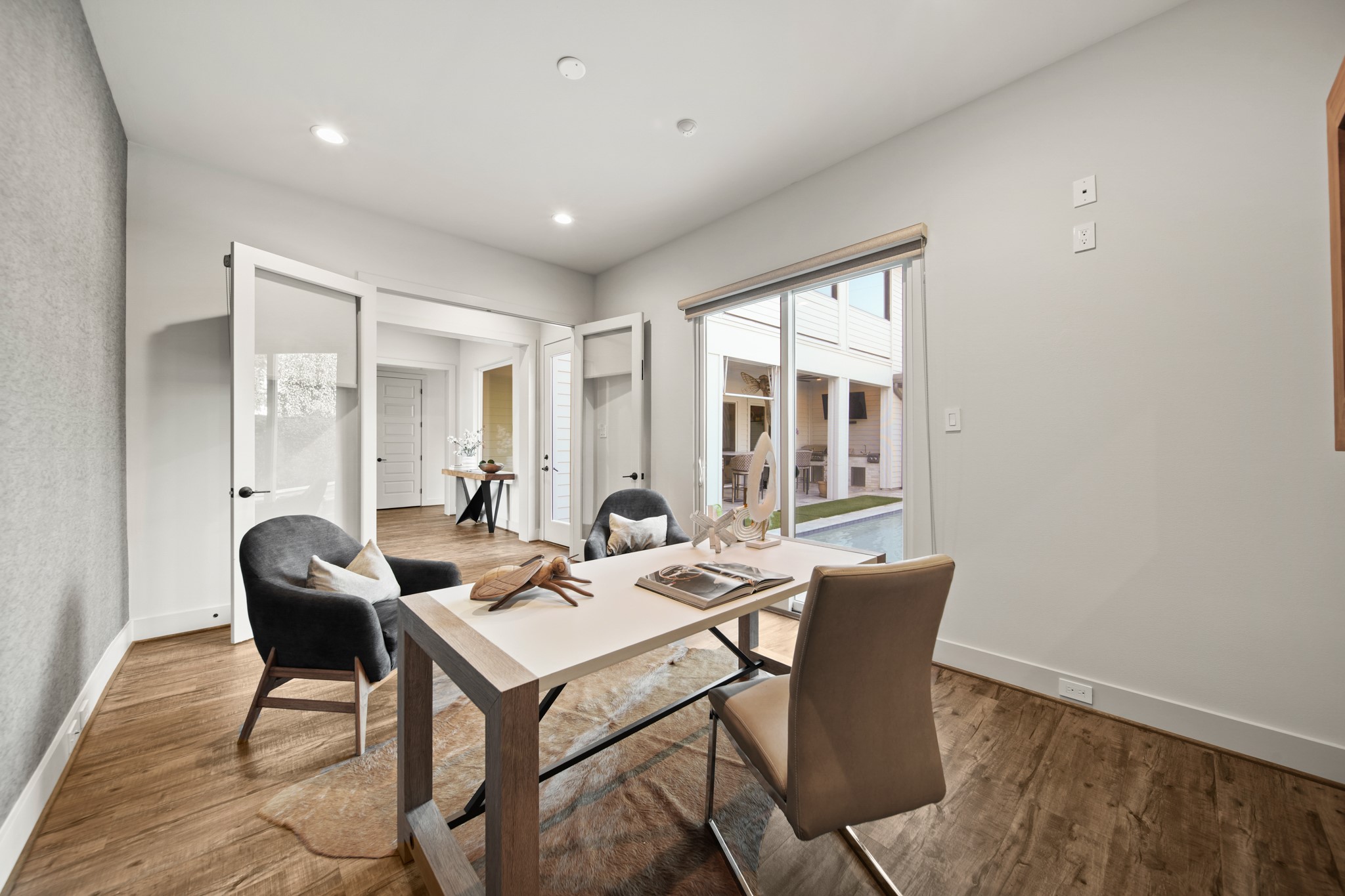 5434 Windswept Lane Houston, TX 77056 - Photo 8 of 45 Glass-paneled French doors enhance the flow between rooms, offering both privacy and openness. Thoughtful design touches—like recessed lighting, subtle decor, and layered textures—combine to deliver a workspace that feels both luxurious and effortlessly livable.