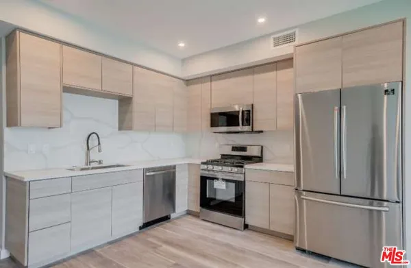 a living room with furniture kitchen view and a potted plant