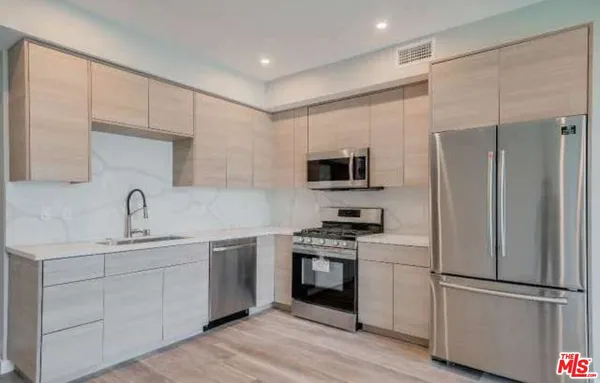 a kitchen with stainless steel appliances a refrigerator stove and sink