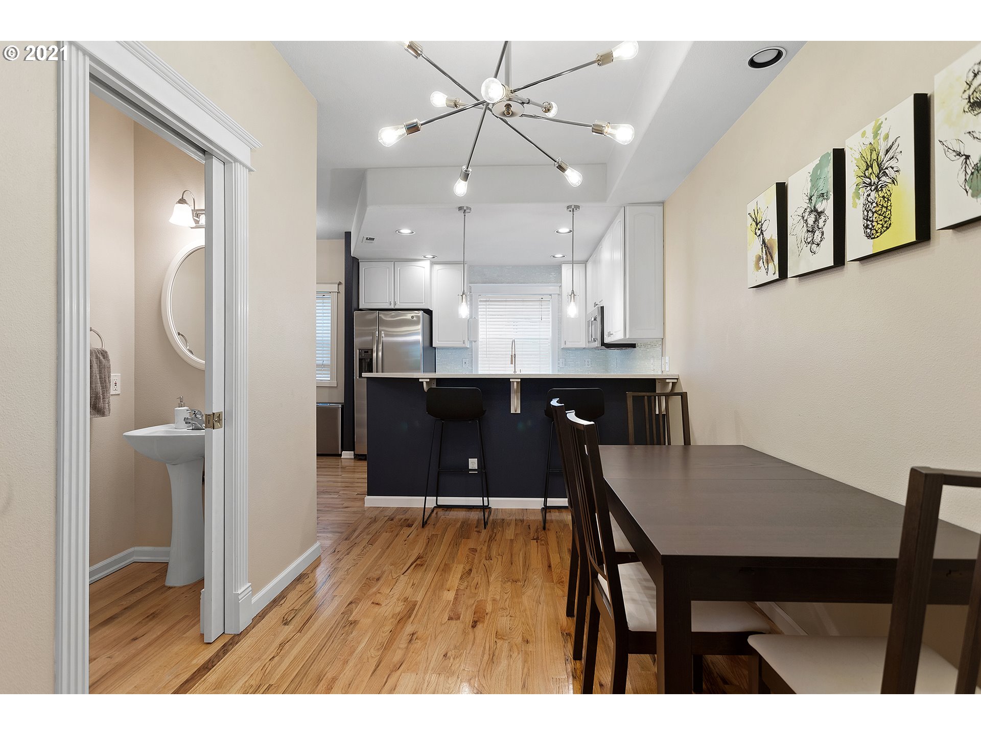 4930 Southwest 1st Avenue Portland, OR 97239 - Photo 11 of 27 a kitchen with kitchen island a dining table chairs stainless steel appliances and cabinets