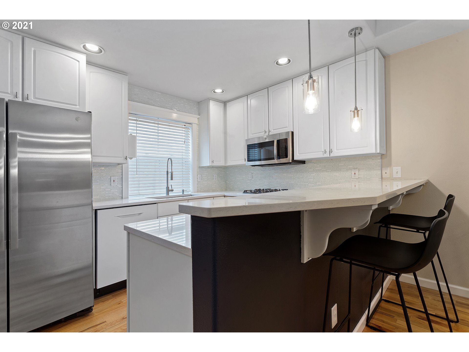 4930 Southwest 1st Avenue Portland, OR 97239 - Photo 7 of 27 a kitchen with kitchen island granite countertop a sink cabinets and stainless steel appliances