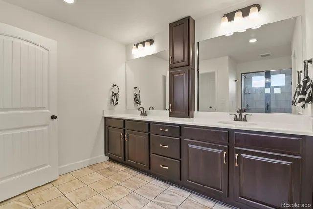 a spacious bathroom with a double vanity sink and a mirror