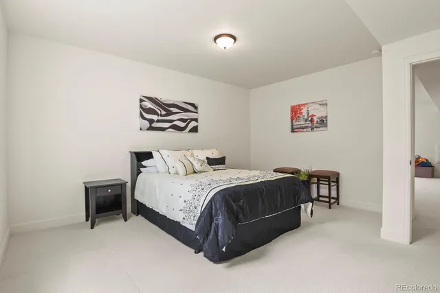 a bedroom with a bed and a painting on the wall