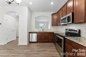 a kitchen with stainless steel appliances granite countertop a stove a sink and a microwave