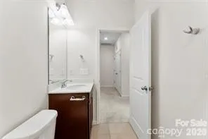a bathroom with a granite countertop sink a toilet a mirror and shower