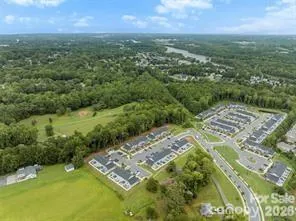 an aerial view of residential houses with outdoor space and trees