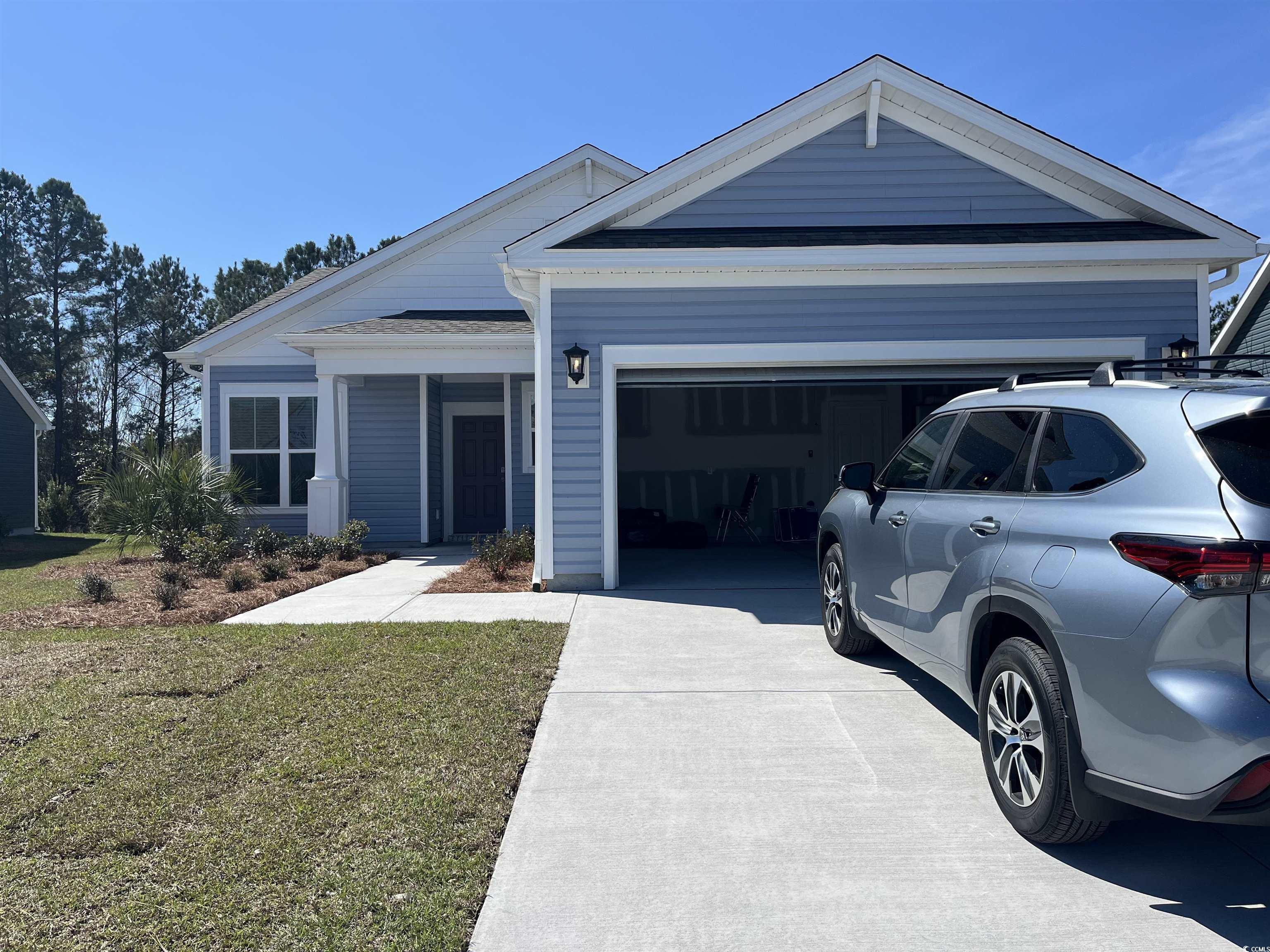 390 Kapalua Loop Little River, SC 29566 - Photo 1 of 13 Craftsman-style house featuring a lawn, roof with shingles, concrete driveway, and an attached garage
