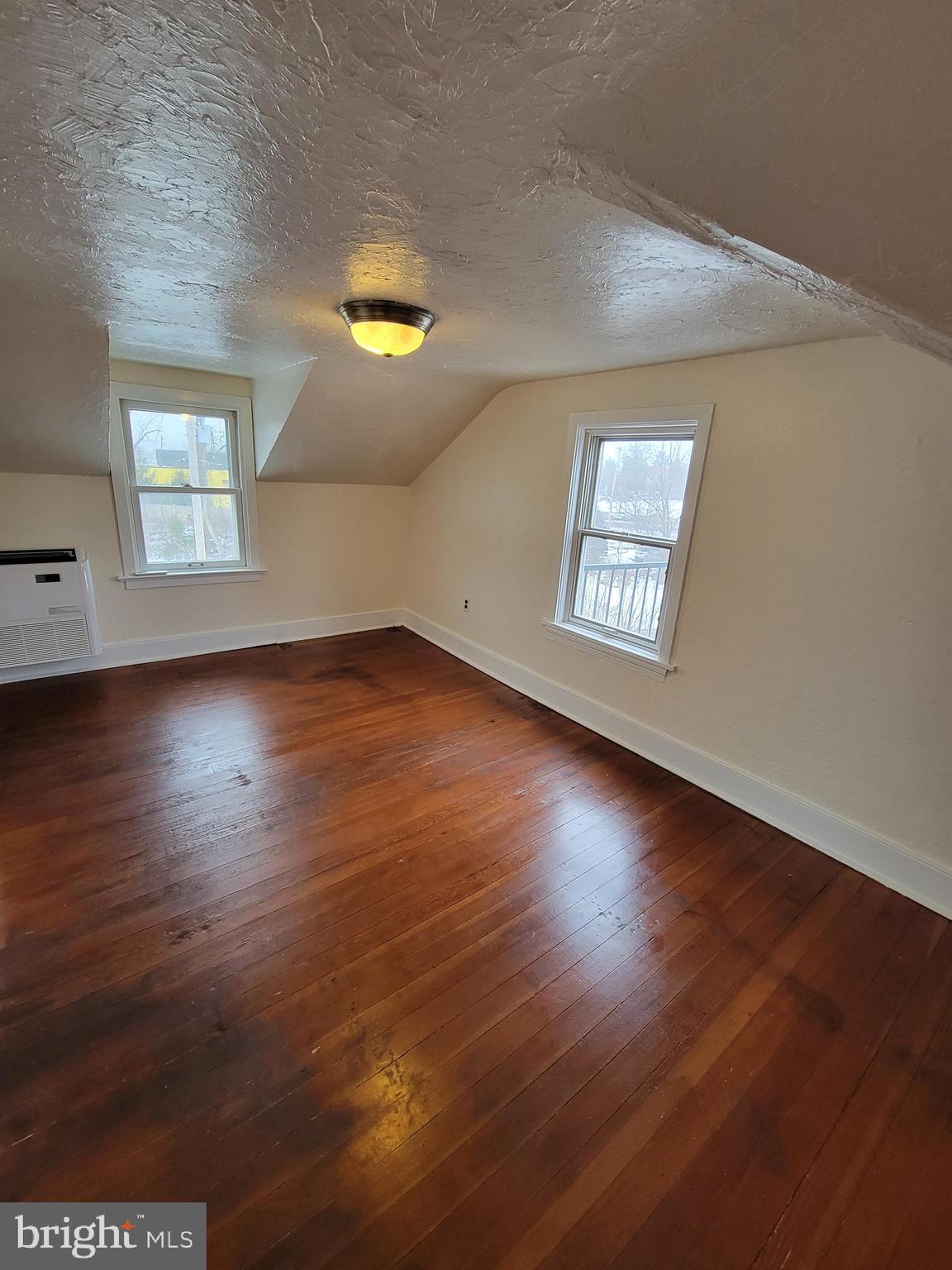 110 Gumbes Road Oaks, PA 19426 - Photo 9 of 13 an empty room with wooden floor and windows
