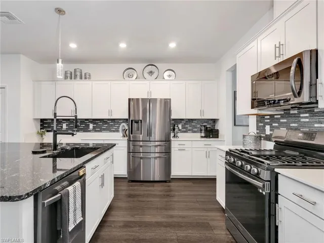 a kitchen with a sink stove top oven and refrigerator