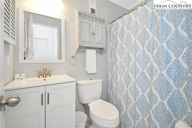 a bathroom with a toilet sink vanity and mirror