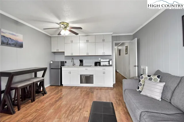 a living room with furniture and kitchen view