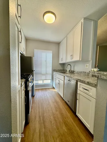 a kitchen with a sink appliances cabinets and a window