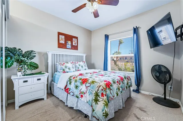 a bedroom with a bed a dresser and potted plants