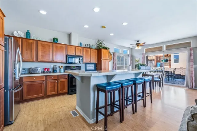 a kitchen with stainless steel appliances granite countertop a table chairs and a refrigerator