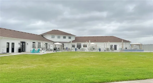 a large white building with a big yard and large trees
