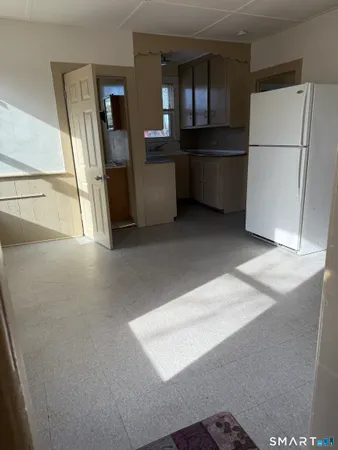 a view of an empty room with a kitchen