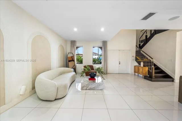 a living room with furniture and a large mirror